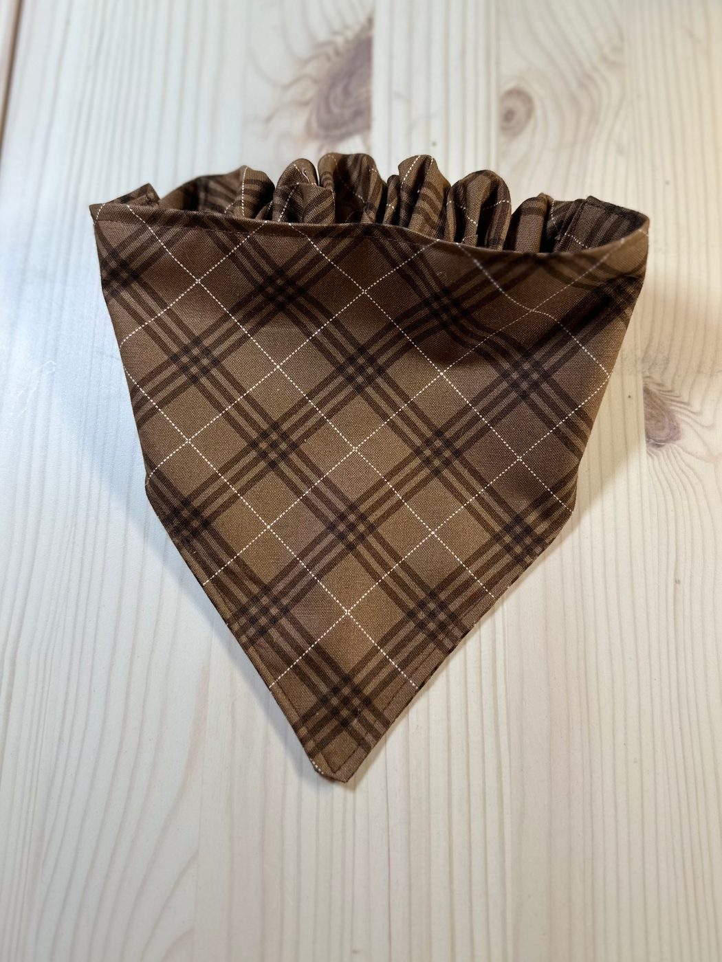 Handmade pet bandana in a warm brown plaid, with a gathered channel that slips over a collar