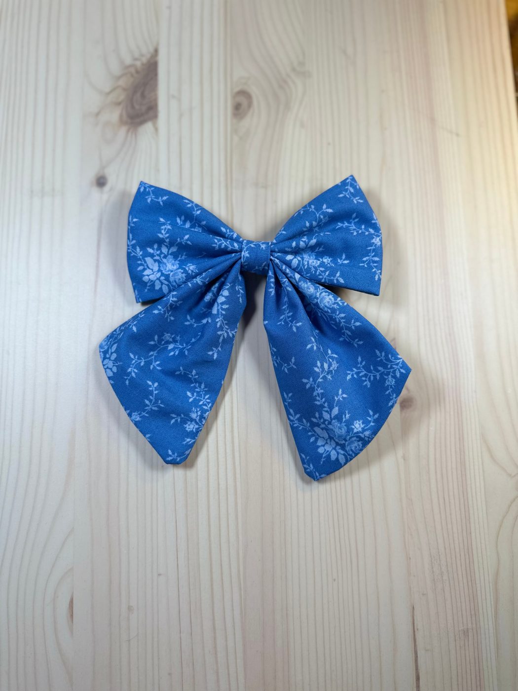 Handmade sailor bow in cornflower-blue cotton with fine white trailing rose vines