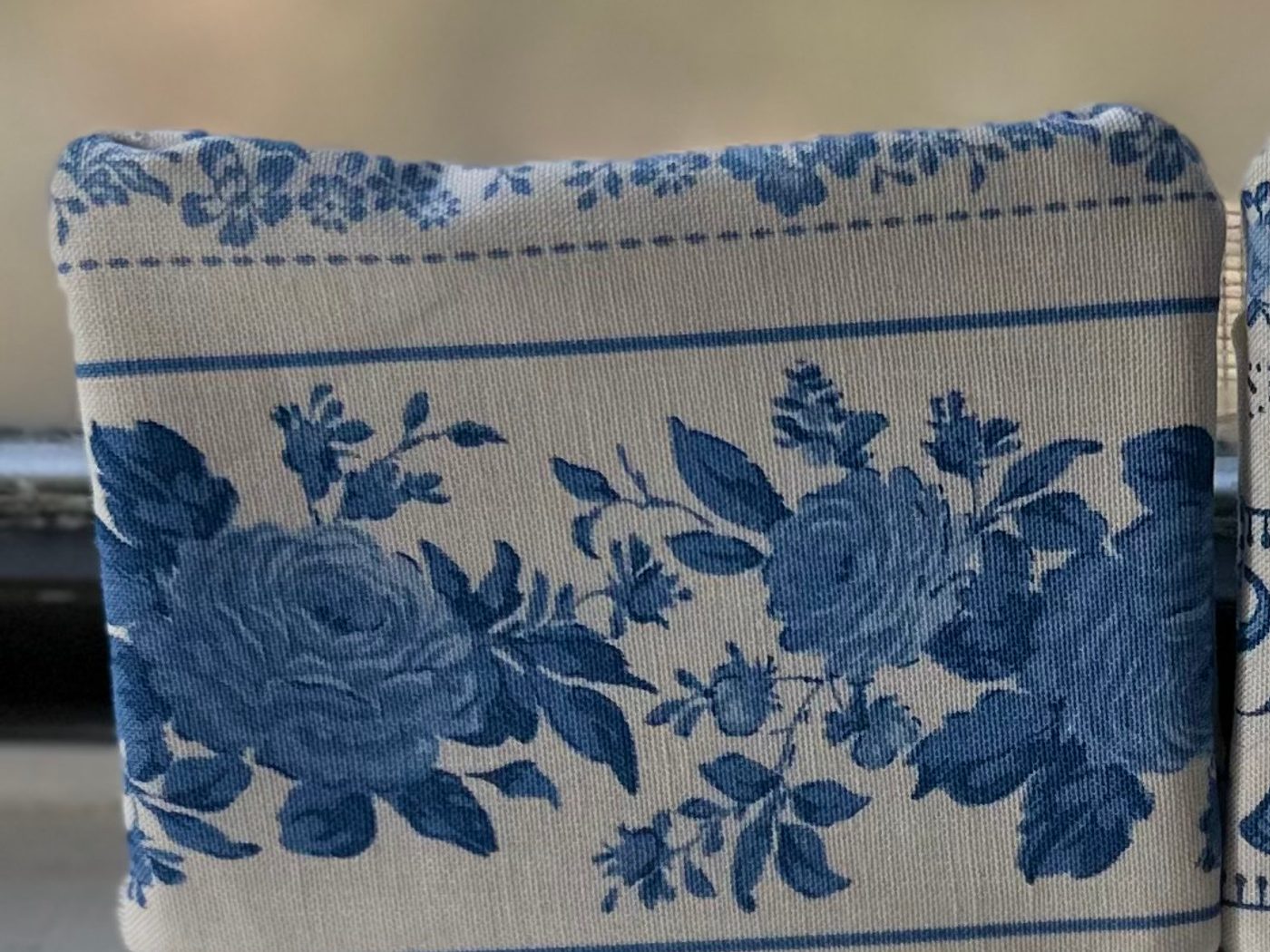 A small handmade fabric gift card holder, cream with a band of blue cabbage roses across the front