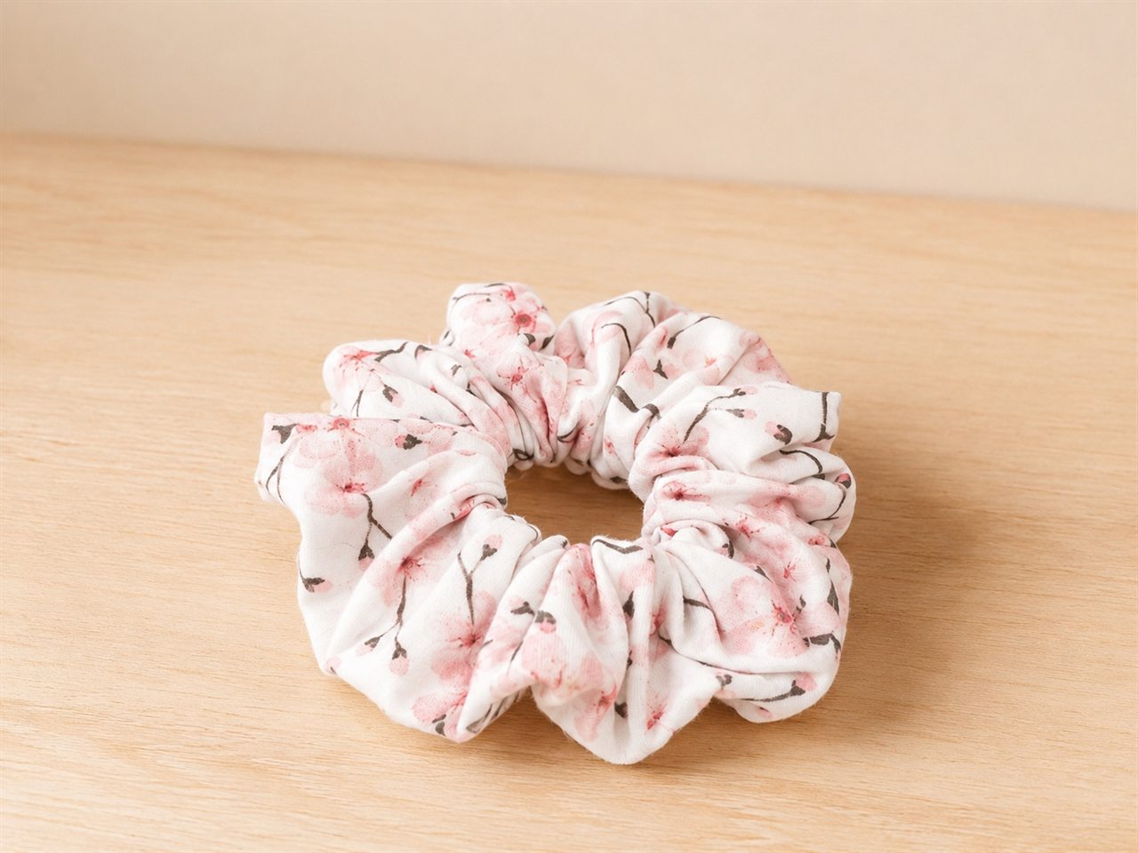 Handmade scrunchie in a pink cherry blossom print on cream
