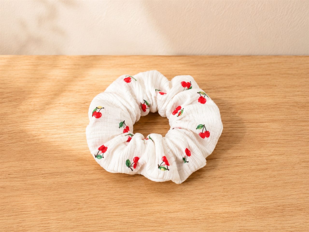 Handmade ribbed scrunchie with a red cherry print on cream