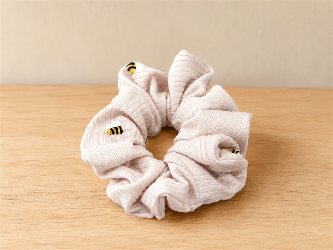 Handmade ribbed blush-pink scrunchie dotted with bees