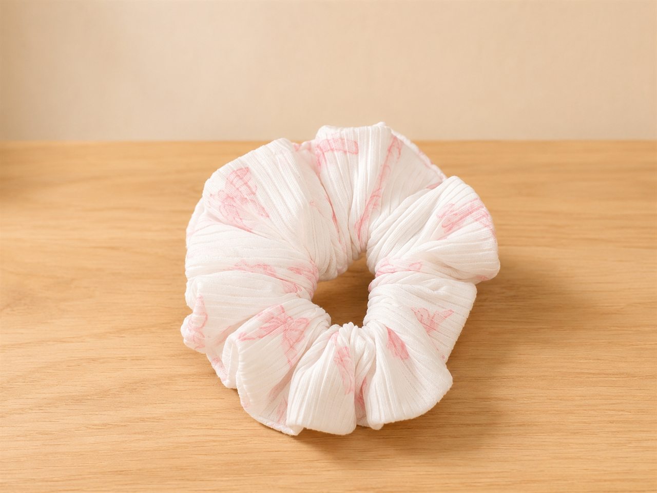 Handmade textured scrunchie with soft pink brushstrokes on cream