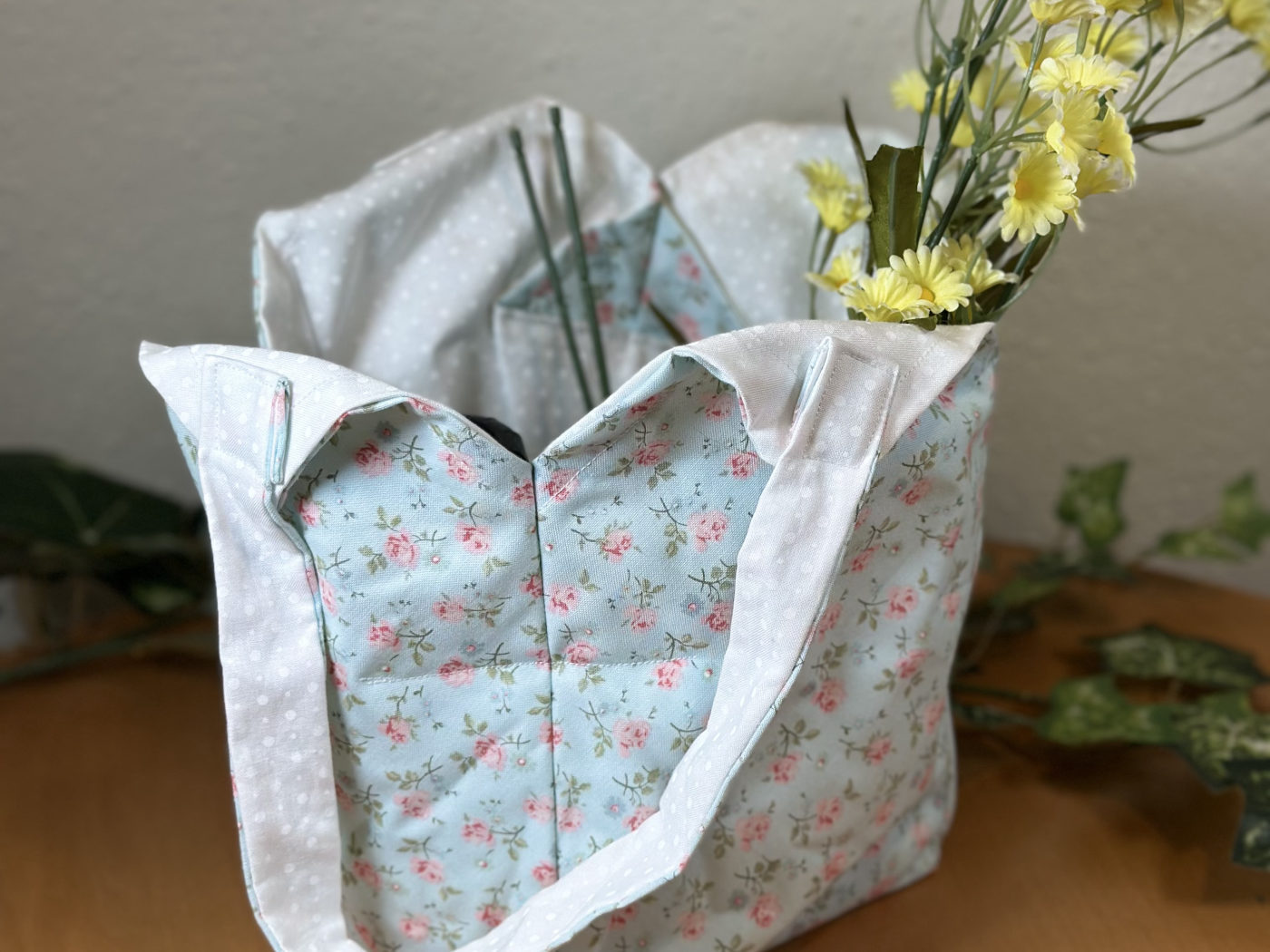 Handmade mini tote in a pale blue print scattered with tiny pink roses