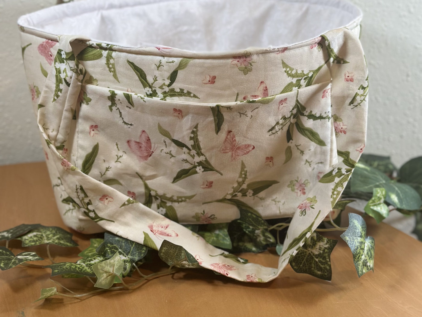 Handmade cream tote with a lily-of-the-valley and pink butterfly print, lined in white